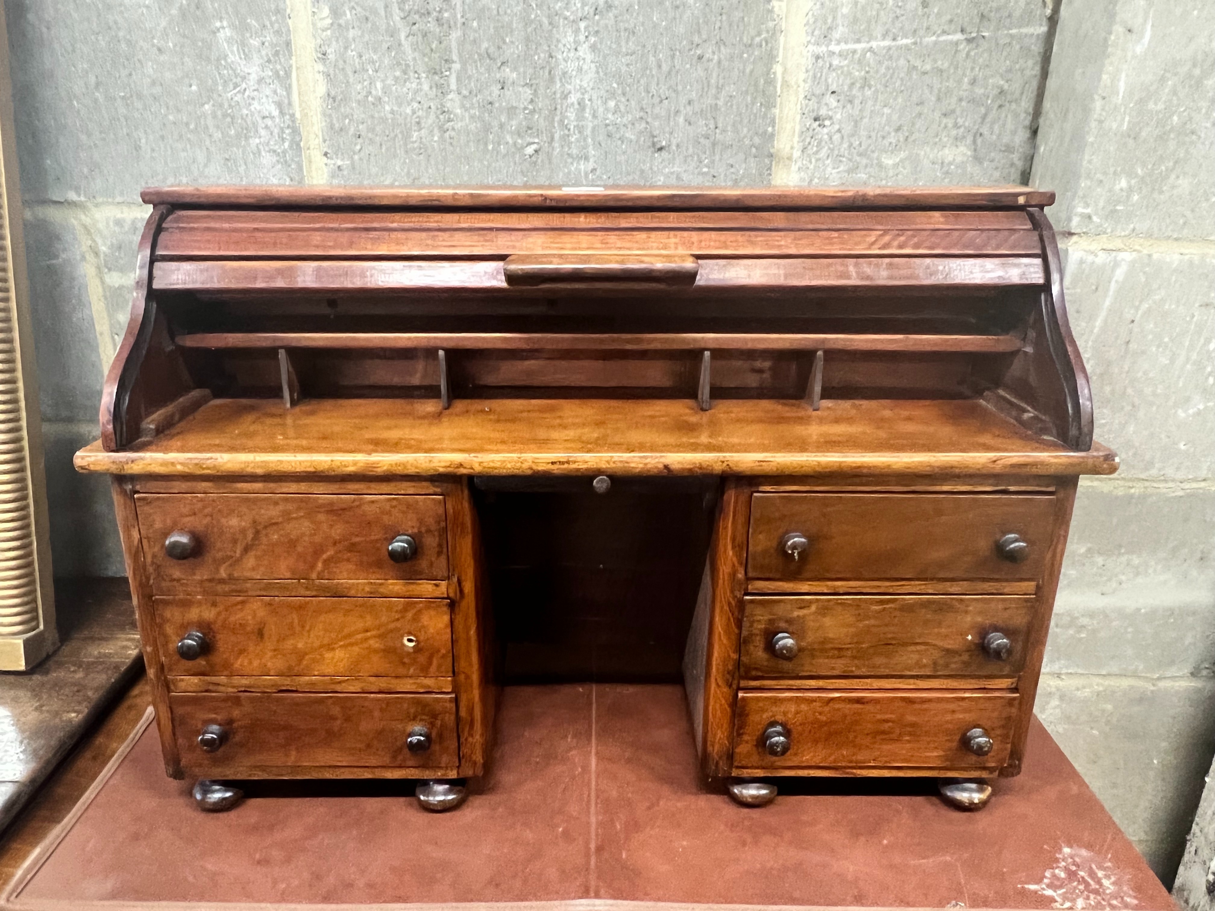 A miniature mahogany and hardwood kneehole tambour desk, width 69cm, depth 22cm, height 45cm.